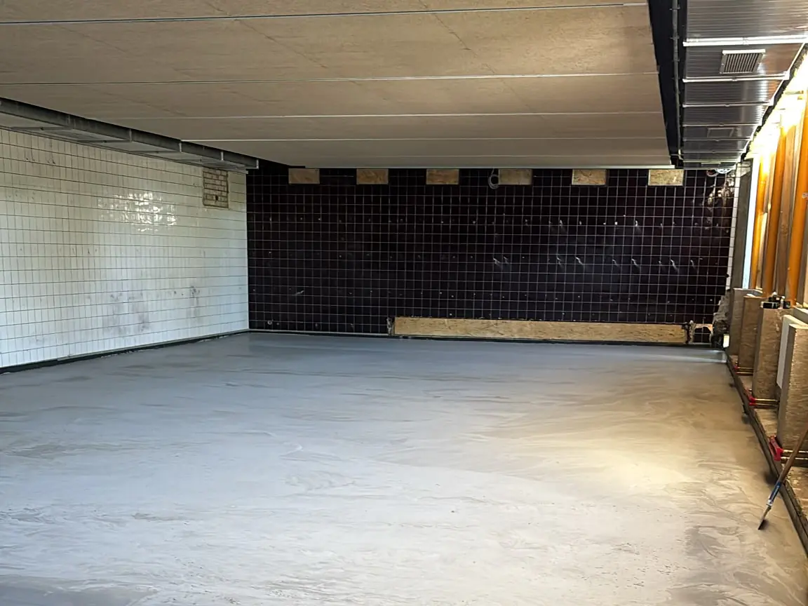 Große Halle im Untergeschoss mit frisch ausgeglichenem Boden während der Bauarbeiten